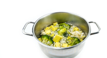 Broccoli and potatoes raw ingredients in the pot prepare to cook