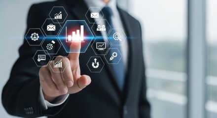 Businessman touching a futuristic screen displaying financial charts and business icons, symbolizing data analysis and digital growth