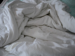 Obraz premium Unmade white hospital bed with crumpled bedding and soft natural light creating a calm clinical atmosphere in a healthcare patient recovery. High quality photo