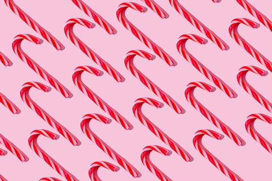 Candy canes arranged on pastel pink background