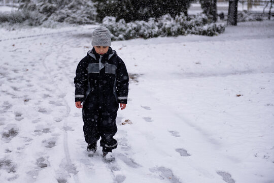 Child walking alone on a snowing winter day