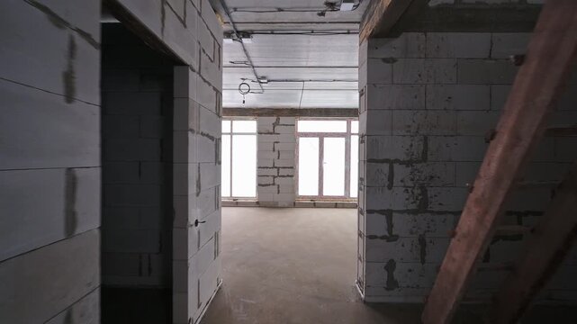 Interior view of a construction site, featuring block walls and window openings