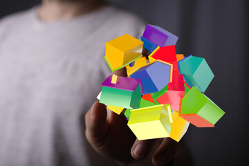 Conceptual image featuring a hand holding 3D rendered colorful houses, symbolizing real estate,...