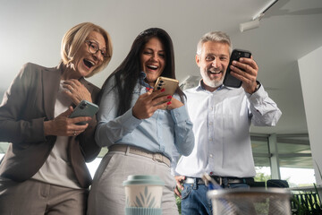 Diverse group of business people celebrating success after meeting in modern office, happy for good news