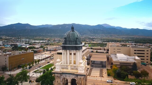 Rising to the top of Colorado Springs Pioneers Museum. Revealing view on the cityscape surrounded by mountain range.