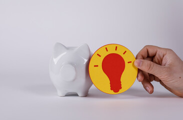 Conceptual image of a piggy bank and a lightbulb suggesting savings, investment, and the power of...