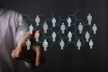 Abstract image of a person's hand interacting with a digital network of people, representing...