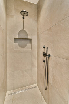 Modern shower design with beige tiles and black fixtures