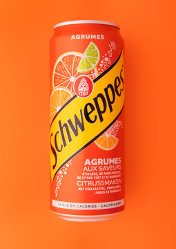 LONDON,UK - FEBRUARY 27,2025: Schweppes carbonated mineral water with citrus fruits top view on orange background.Since 1783.