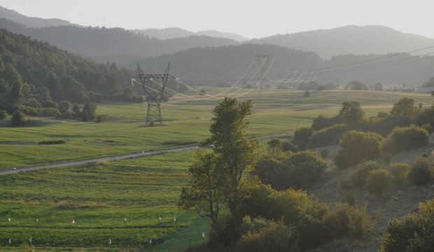 A view of the transmission line in a mountainous environment. An electric power high voltage transmission line.