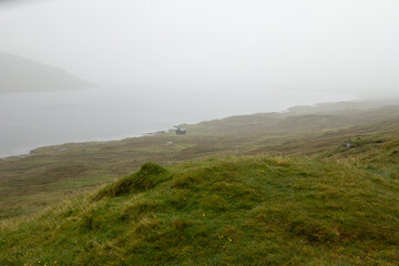 Lake Leitisvatn (Sørvágsvatn) on the Faroe Islands covered with fog, creating a mystical and serene atmosphere loved by nature travelers and photographers.