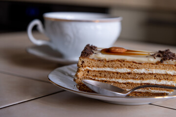 Delicious layered cake served with a cup of coffee on a table