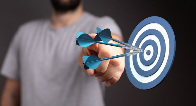 Close-up of a hand throwing darts at a target. Concepts of achievement, goals, business, precision, and strategy. Great for success, competition