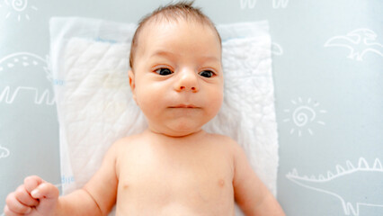 Cherubic baby laying on soft bedding, looking serene