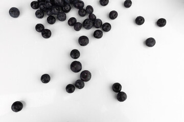 Blueberries scattered on a white background.
