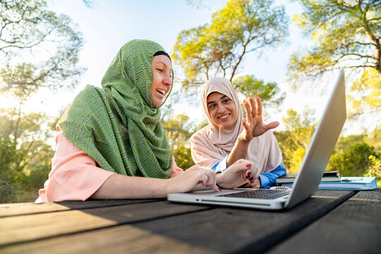 Muslim women podcasting in a serene park setting