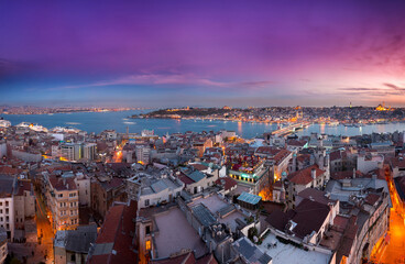 A stunning panoramic view of Istanbul, Turkey, at sunset. This cityscape overlooks the Golden Horn and Galata Bridge, with the historic Sultanahmet mosque skyline silhouetted against a colorful sky.