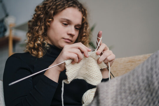 focused knitting session, woman carefully managing stitch tension during mindful knitting process