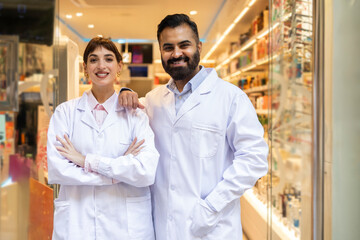 Friendly pharmacists standing in a well stocked pharmacy