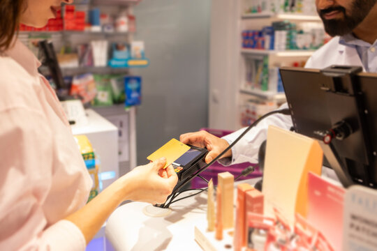 Pharmacist and customer interaction at checkout counter