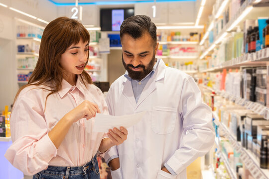 Pharmacist assisting customer in modern pharmacy