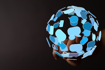 A hand touching a sphere formed of speech bubbles. Digital communication, social media, and global connection. Represents conversations and the
