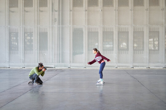 Girl roller skating while a photographer captures her movements