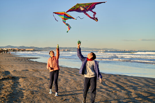 Children fly colorful kites on a sunny beach
