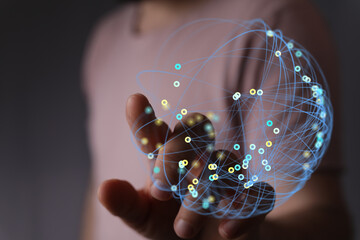 Abstract image of a hand holding a glowing digital sphere representing global connection,...