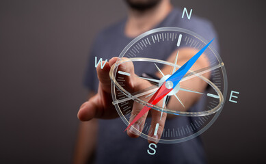 Close-up of a person's hand interacting with a 3D rendered compass. Conceptual representation of...