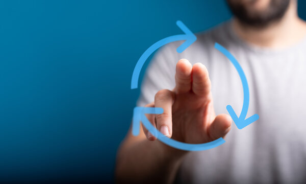Close-up of a man's hand interacting with a digital circle of arrows. Illustrating concepts like renewal, connection and process.