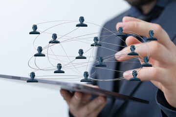 A close-up shot showcasing a digital network concept visualized with human figures connected to a tablet. Symbolizing teamwork, communication, a