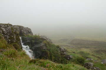 Waterfall in T&oacute;rshavn, Faroe Islands, surrounded by mist and fog, ideal for hiking.