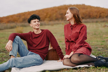 Candid outdoor portrait of a young couple sharing a genuine, authentic moment on a picnic blanket...