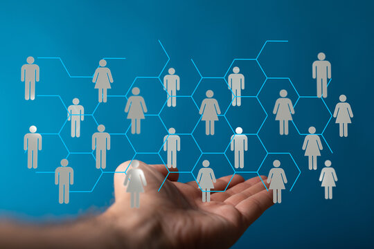 Image of interconnected people held in a hand, symbolizing networking, community, and global relationships. Ideal for illustrating teamwork, com