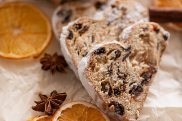 Christmas stollen on wooden background. Traditional christmas german dessert cut into pieces. Cake with nuts, raisins with marzipan and dried fruit on cutting board. baking for xmas