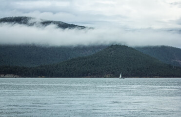 Sailboat by a foggy mountain