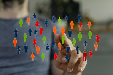 Hand reaching towards a collection of colorful figures symbolizing community, network, social interaction and teamwork. Diverse people coming to