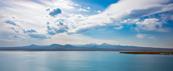 A beautiful blue sky with a few clouds and a calm ocean