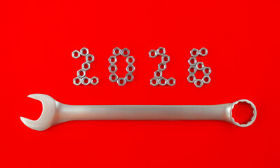 Number 2026 by metal nuts and wrench on a red background. 2026 year