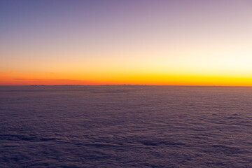 Sunrise over the Atlantic Ocean with a sea of clouds, viewed from an airplane over the Azores.