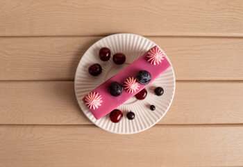 Top View of Berry Layer Cake Slice with Cherries and Blueberries on Plate