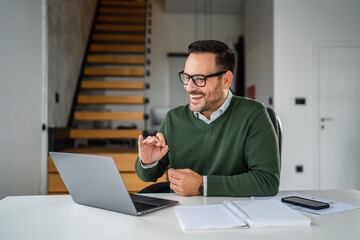 Businessman having video call on laptop at home office