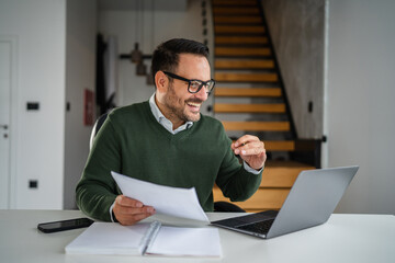 Businessman having video call on laptop at home office