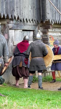 Medieval knights storm the wooden gate in the castle. Reconstruction of knightly battles
