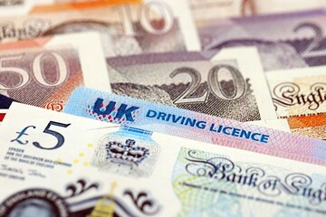 United Kingdom driving license card on UK British pounds money close up