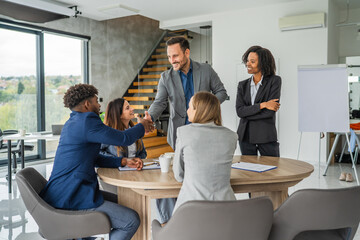 Business people handshaking in meeting, celebrating successful deal