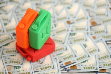 Petroleum or gasoline canister reservoir lies on big amount of dollar bills. Concept of petrol...