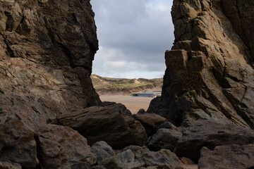 Rock formations frame a sandy beach in Holywell Bay - Cornwall - UK