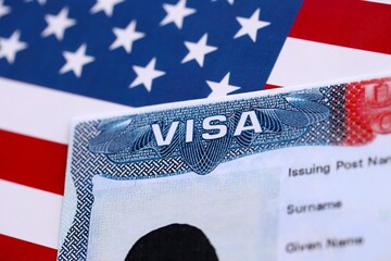 U.S. VISA United States of America. American Tourist or Green Card Visa on flag background close up
